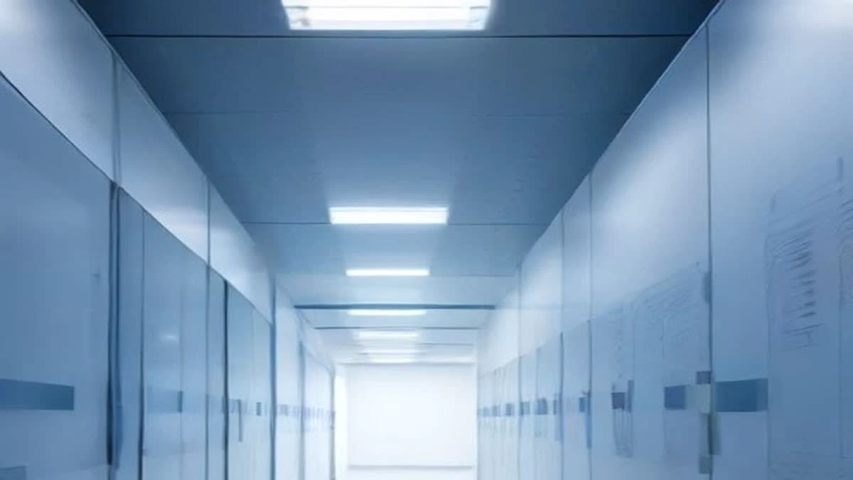 Aisle of white server racks with blue indicator lights in a modern data centre