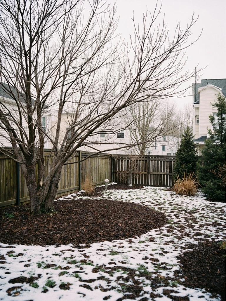 A residential backyard redesign in early spring snowmelt, with bare shrubs and a bluestone path on a small urban lot in Madison, Wisconsin.
